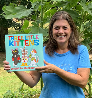 smiling librarian holding Three Little Kittens book